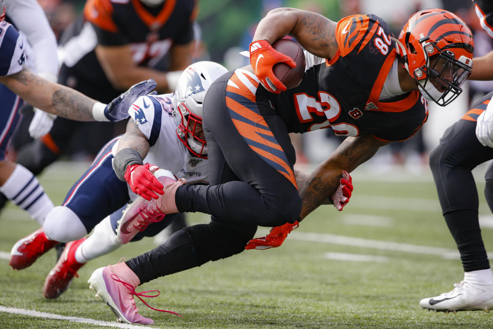 Cincinnati Bengals running back Joe Mixon (28) runs the ball against New England Patriots strong safety Patrick Chung, left, in the first half of an NFL football game, Sunday, Dec. 15, 2019, in Cincinnati. (AP Photo/Gary Landers)