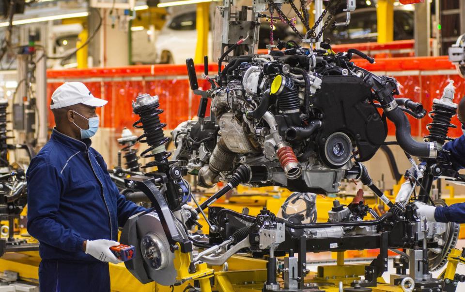 A worker wearing a protective face mask secures a suspension unit to an automobile chassis on the production line at the BMW South Africa Pty Ltd. Rosslyn plant in Midrand, South Africa, on Friday, May 29, 2020. Most businesses, including steel mills, factories and all retail outlets, can reopen on condition they observe strict health protocols and ensure their workers observe social distancing. Photographer: Waldo Swiegers/Bloomberg - Waldo Swiegers/Bloomberg