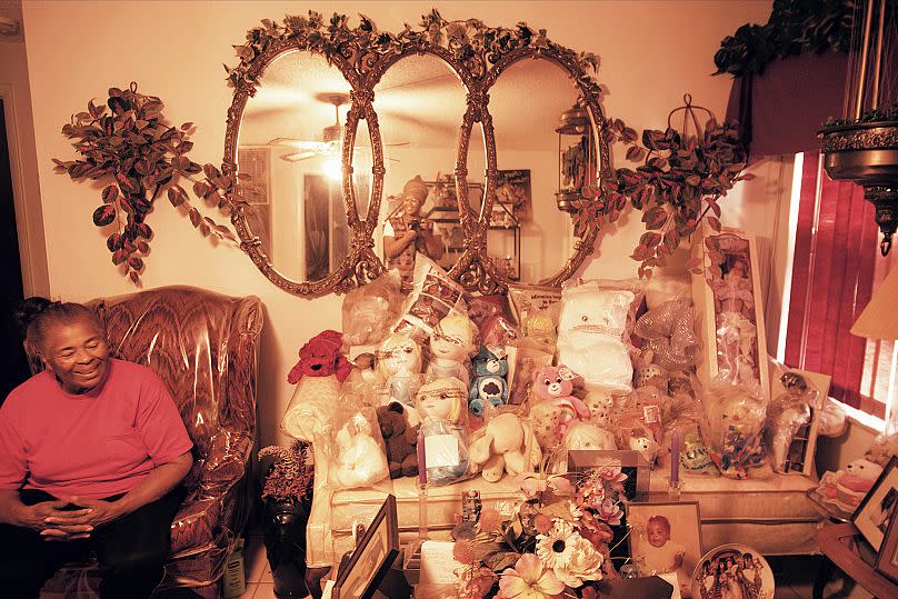 Ms. Daisy in her home with her toy collection.