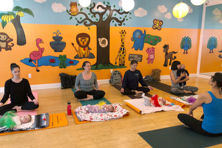 Mothers and babies (L-R) Ashley Beller and her son Mason, 5 months, Samantha Schwoll and her daughter Charlotte, 5 months, Amanda Leimgruber and her daughter Emelia, 6 months and Sarah Oliva and her son Nico, 3 months participate in a yoga class at Zooga Yoga in Culver City, California, U.S. March 20, 2019. Picture taken March 20, 2019. REUTERS/Jane Ross