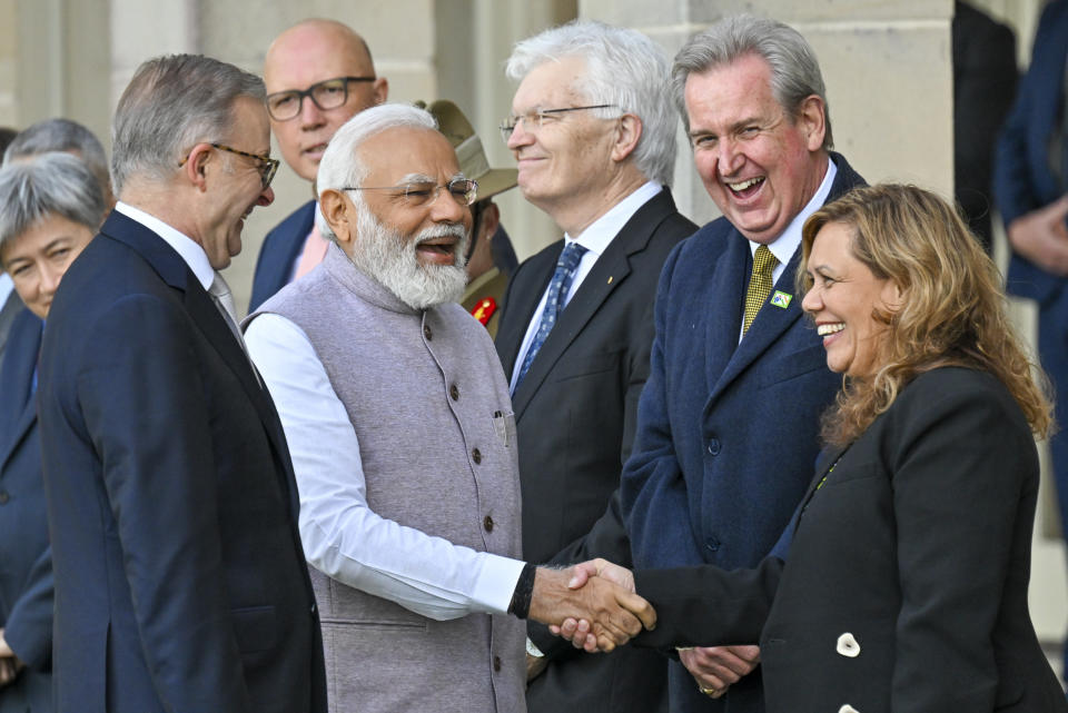 India's Prime Minister Narendra Modi, second left, reacts as he shakes hands with officials as Australia's Prime Minister Anthony Albanese, left, watches during a ceremonial welcome at Admiralty House in Sydney Wednesday, May 24, 2023. Modi is the only leader of the so-called Quad nations to continue with his scheduled visit to Australia after U.S. President Joe Biden pulled out of a planned meeting of the group in Sydney to return to Washington to focus on debt limit talks. (Saeed Khan, Pool Photo via AP)