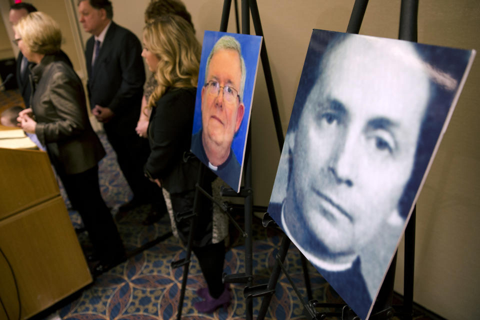 FILE - In this Nov. 13, 2013, file photo, a photo of Rev. Robert Brennan, right, is displayed during a news conference in Philadelphia. Federal prosecutors in Philadelphia charged Brennan, a former Roman Catholic priest with lying to the FBI about whether he knew the accuser and his family. Two years ago U.S. attorney William McSwain in Philadelphia joined the long line of ambitious prosecutors investigating the Roman Catholic church's handling of priest-abuse complaints. The Justice Department had never brought a conspiracy case against the church. McSwain sent subpoenas to dioceses across Pennsylvania asking them to turn over their files and submit to grand jury testimony if asked. The dioceses pledged to comply. But as McSwain's tenure nears its end as President-elect Joe Biden takes office next month, there's no sign that any sweeping church indictment is afoot. (AP Photo/Matt Rourke, File)