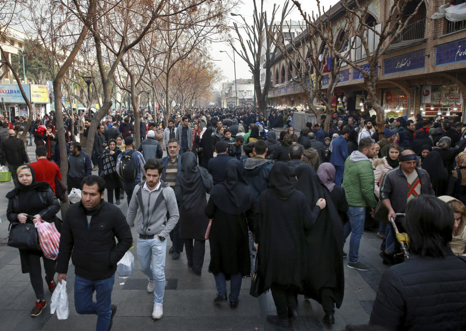 In this Thursday, Feb. 7, 2019 photo, people shop near the Grand Bazaar in Tehran, Iran. The economy faces multiple struggles as the country marks the 40th anniversary of the Islamic Revolution. Inflation continues to rise as its currency depreciates and university graduates are unable to find jobs. Some of the challenges stem from the re-imposition of U.S. sanctions while other problems date back to the time of the revolution. (AP Photo/Vahid Salemi)