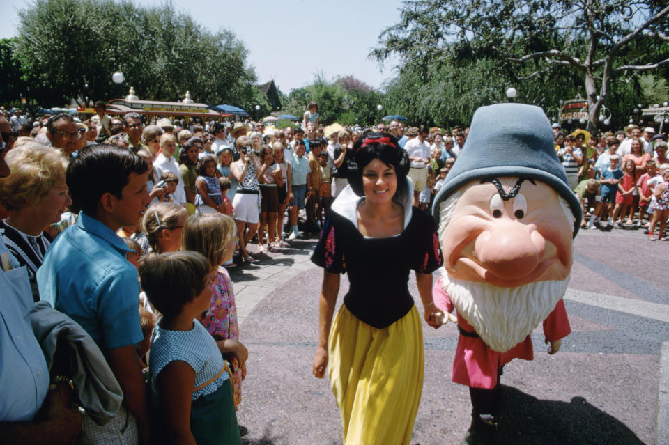 A crowd gathers to watch Snow White and Grumpy at Disneyland in 1969.