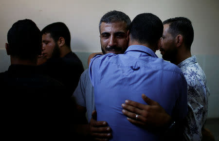 A relative of a Palestinian, who was killed in an Israeli air strike, is consoled at a hospital in the northern Gaza Strip October 17, 2018. REUTERS/Mohammed Salem