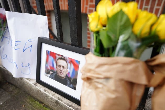 An image of Navalny is seen alongside floral tributes near the Russian Embassy in London following news that the jailed Russian opposition leader has died.
