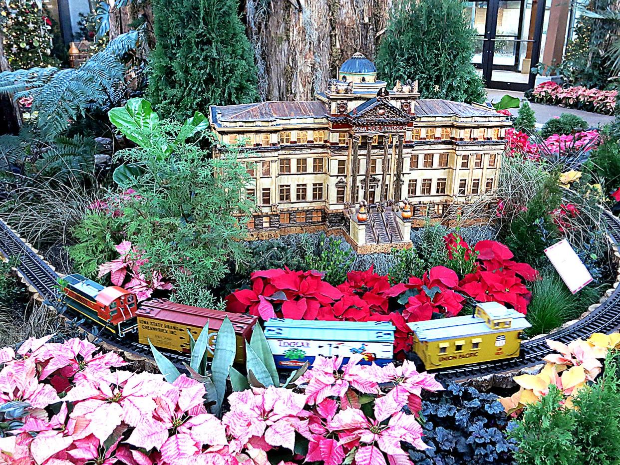 The RG Express chugs past a replica of Beardshear Hall, which is made of natural materials like birch bark, monkey face pods, mung beans and peppercorns, in a past year's display. The RG Express is running now through Jan. 20 at Reiman Gardens.