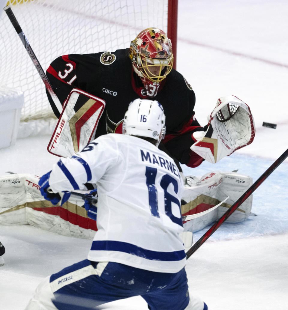 Toronto Maple Leafs right wing Mitchell Marner (16) shoots the puck wide of the net past Ottawa Senators goaltender Anton Forsberg, top, during second-period NHL hockey game action Thursday, Dec. 7, 2023, in Ottawa. (Adrian Wyld/The Canadian Press via AP)