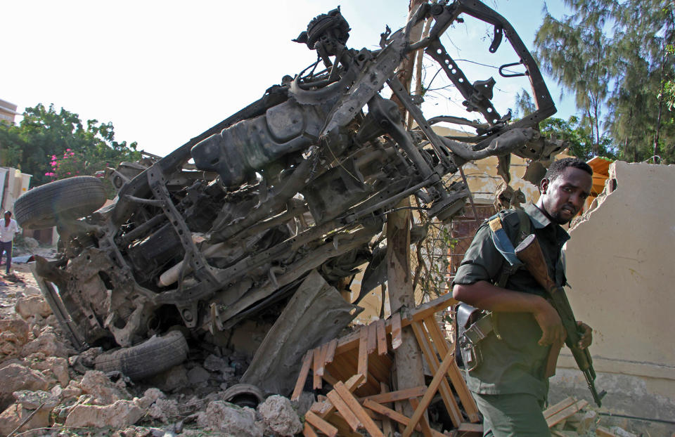 A soldier stands near wreakage