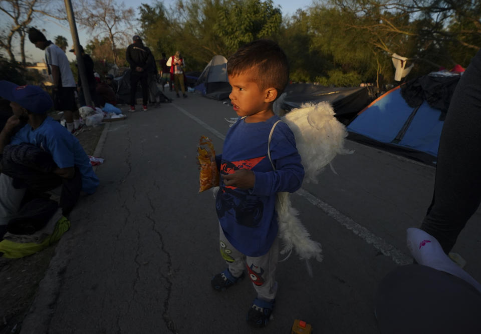 A Venezuelan migrant boy wears angel wings at a makeshift camp of migrant, in Matamoros, Mexico, Thursday, Dec. 22, 2022. (AP Photo/Fernando Llano)