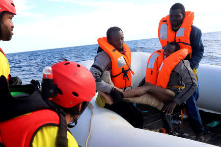 A wounded migrant reacts as he is carried by two fellow migrants during a rescue operation. REUTERS/Giorgos Moutafis