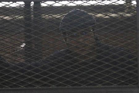 Activist Ahmed Maher stands behind bars at a court in Cairo April 7, 2014. REUTERS/Al Youm Al Saabi Newspaper