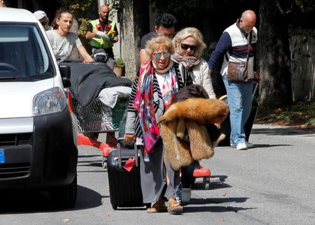 People walk with their belongings following an earthquake in Amatrice, central Italy, August 24, 2016. REUTERS/Ciro De Luca