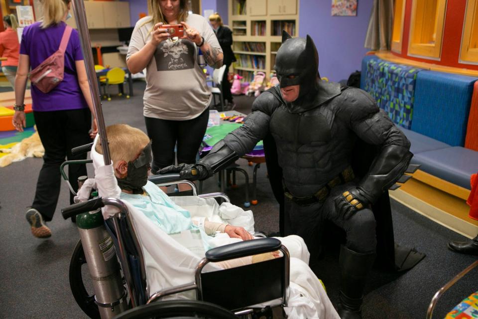 Eight year-old burn victim Brantley Parrish gets a visit with Batman at UMC Children's Hospital on National Superhero Day.