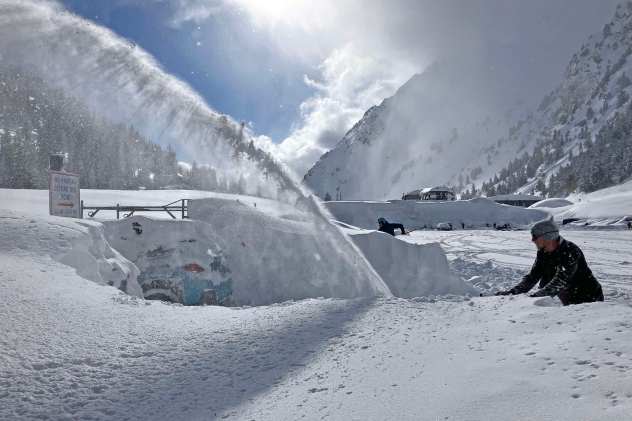 Employees work to locate and extract their vehicles following a 66.5-inch storm at Alta Ski Area in Utah on April 5, 2023