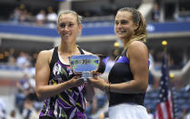 Elise Mertens, of Belgium, left, poses for photos with the trophy with doubles partner Arena Sabalenka, of Belarus, after winning the women's doubles final against Victoria Azarenka, of Belarus, and Ashleigh Barty, of Australia, at the U.S. Open tennis championships Sunday, Sept. 8, 2019, in New York. (AP Photo/Sarah Stier)