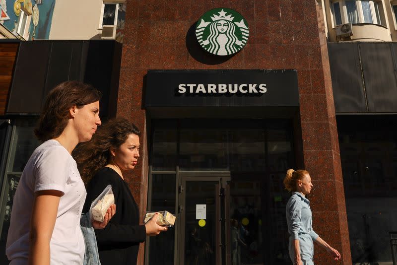Pedestrians walk past a closed Starbucks cafe in Moscow