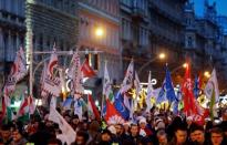 People walk with flags during a protest against a proposed new labor law, billed as the "slave law" in Budapest, Hungary, December 16, 2018. REUTERS/Leonhard Foeger