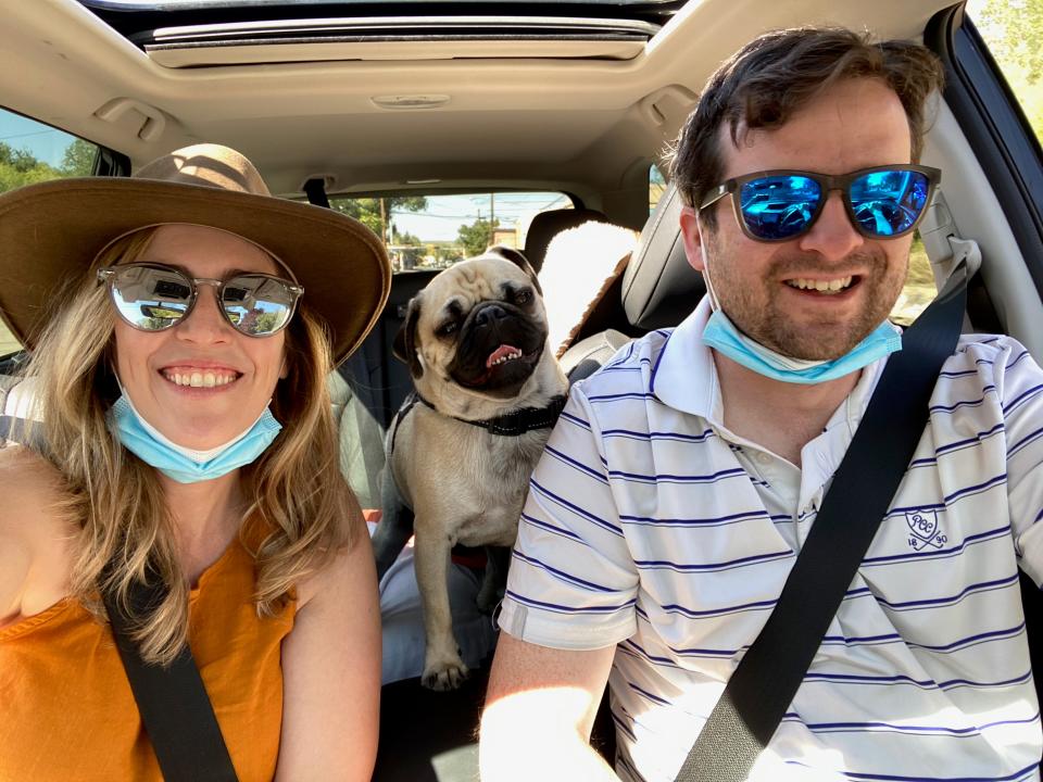 A man, woman, and a dog in a car.