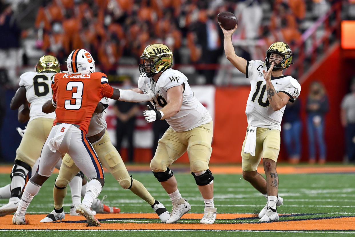 Wake Forest quarterback Sam Hartman, right, throws a pass during the first half of an NCAA college football game against Syracuse in Syracuse, N.Y., Saturday, Oct. 9, 2021. (AP Photo/Adrian Kraus)