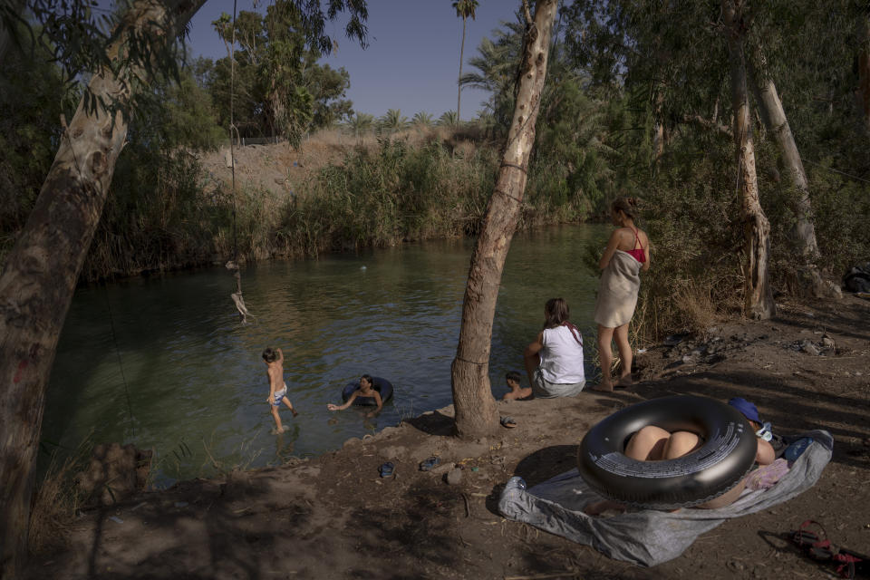 People spend the day at the Jordan River near Kibbutz Kinneret in northern Israel on Saturday, July 30, 2022. Environmental group EcoPeace Middle East has been urging regional collaboration on the Jordan between rivals who have long had every motivation to squeeze as much water as possible out of the river or its tributaries. (AP Photo/Oded Balilty)