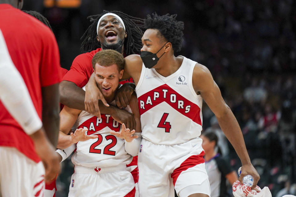 Toronto Raptors guard Malachi Flynn (22) celebrates his buzzer-beater with teammates Precious Achiuwa and Scottie Barnes (4) during second-half preseason NBA basketball game action against the Houston Rockets in Toronto, Monday, Oct. 11, 2021. (Evan Buhler/The Canadian Press via AP)