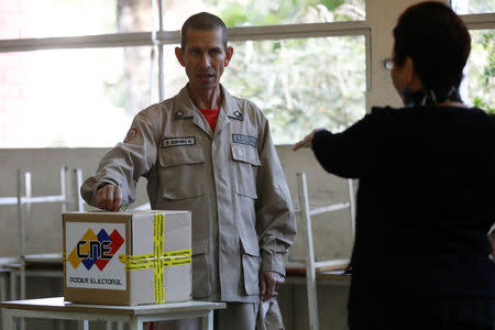 A militia member casts his vote at a polling station during the municipal legislators election in Caracas, Venezuela December 9, 2018. REUTERS/Marco Bello