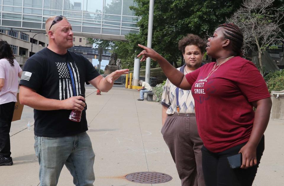 Chad of Tuscarawas County, left, defends the actions of the police as he argues with protester Ayeshia Wimms in front of the Akron Police Department Friday in downtown Akron.