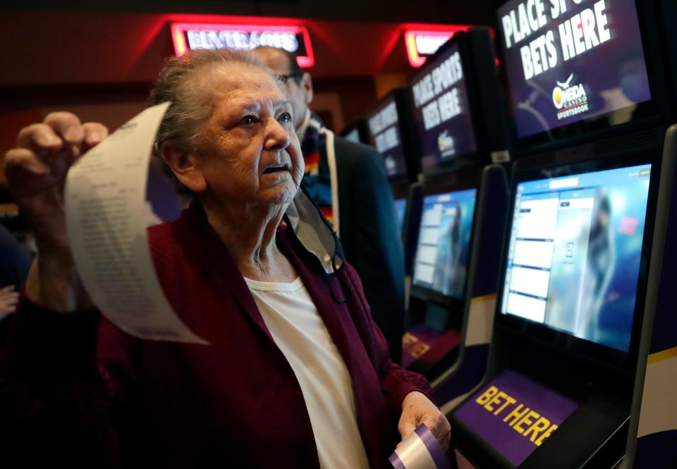 Alma Webster holds up the bet she placed at the opening event for Oneida Casino's sports betting operation on Nov. 30, 2021, in Ashwaubenon, Wis.