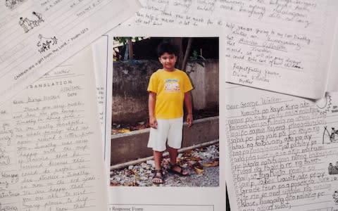 A picture of Timothy, aged 7, with a letter he sent to his pen pal former US President George HW Bush - Credit: AFP