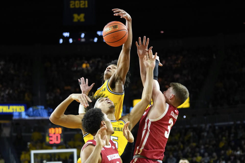 Michigan's Terrance Williams II (5) and Kobe Bufkin (2) battle with Wisconsin guard Connor Essegian (3) for the ball in the second half of an NCAA college basketball game in Ann Arbor, Mich., Sunday, Feb. 26, 2023. (AP Photo/Paul Sancya)