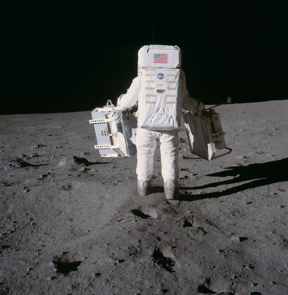 Astronaut Buzz Aldrin deploys scientific equipment on the moon, while Neil Armstrong takes the picture.