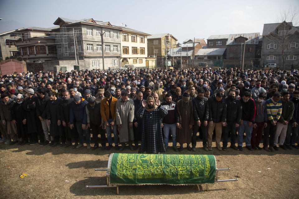 Kashmiri Muslims offer funeral prayers near the coffin of Basharat Ahmad Zargar in Srinagar, Indian-controlled Kashmir, Sunday, Feb.14, 2021. Zargar, who was working at a power project, was among the dozens killed after a part of a Himalayan glacier broke off on February 7 sending a devastating flood downriver slamming into two hydropower projects in northern India. (AP Photo/Mukhtar Khan)