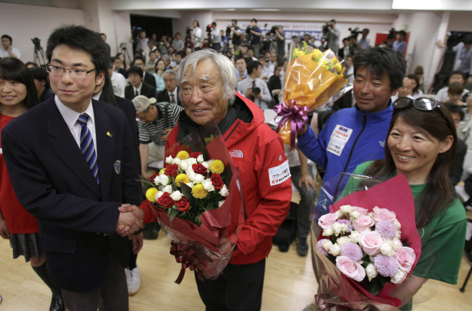 Yuichiro Miura, center, an 80-year-old Japanese mountaineer who became the oldest person to reach the top of Mount Everest last Thursday, poses for photographers before speaking at a press conference at CLARK Memorial International High School in Tokyo, Wednesday, May 29, 2013. Miura said he almost died during his descent and does not plan another climb of the world’s highest peak, though he hopes to do plenty of skiing.  (AP Photo/Shizuo Kambayashi)