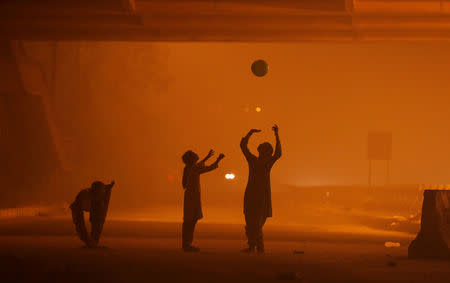 Girls play with a balloon under a flyover amidst the heavy smog in New Delhi, India, November 6, 2016. REUTERS/Adnan Abidi