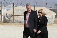 Canada's Prime Minister Stephen Harper (L) and his wife Laureen take a tour at the main center of the World Food Program during their visit to Al Zaatari refugee camp, in the Jordanian city of Mafraq, near the border with Syria January 24, 2014. REUTERS/Muhammad Hamed (JORDAN - Tags: POLITICS SOCIETY IMMIGRATION CIVIL UNREST)