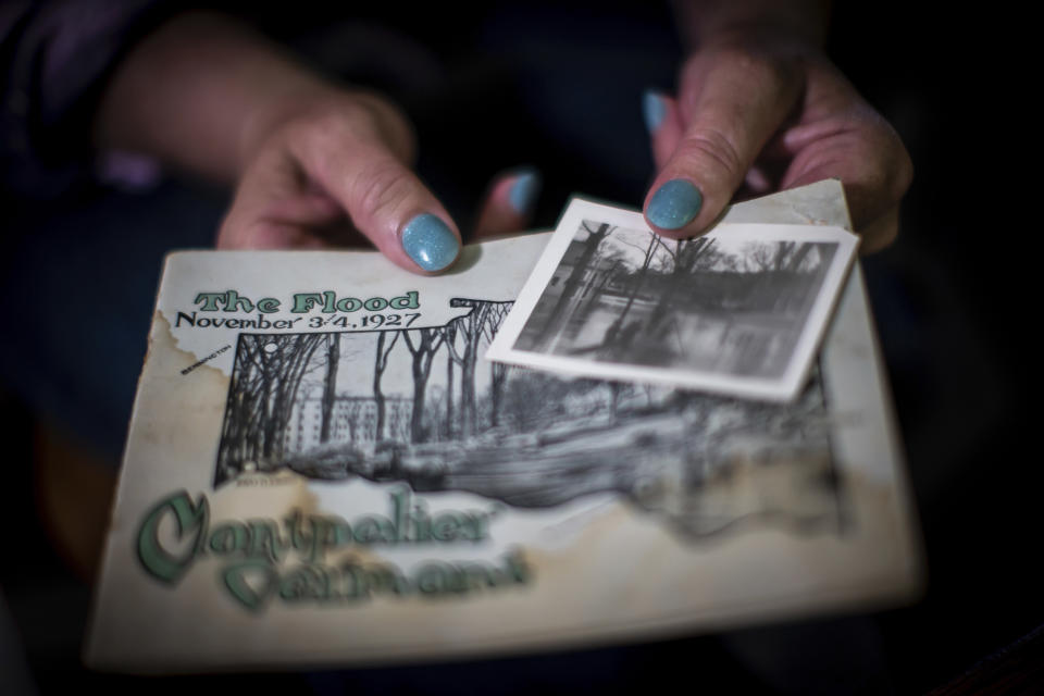 Lisa Edson Neveu, 52 holds a brochure of 1927 flood in Montpelier, Vt. in her hands, July 3, 2024. A year after catastrophic flooding inundated parts of Vermont, some homeowners are still in the throes of recovery. (AP Photo/ Dmitry Belyakov)