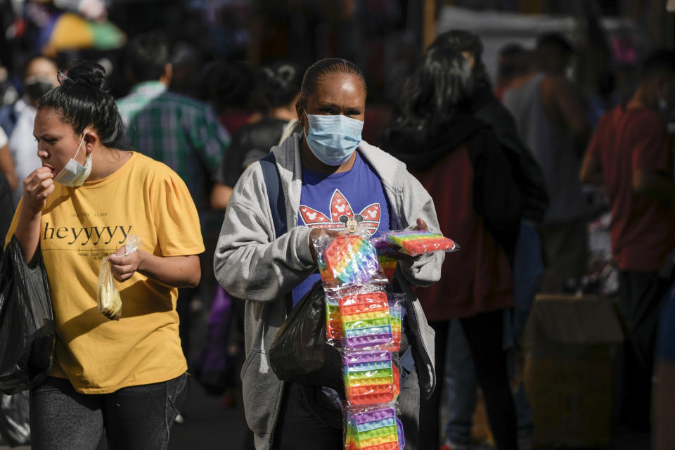 A vendor offers plastics trinkets in the Comayaguela market on the outskirts of Tegucigalpa, days after general elections in Honduras, Tuesday, Nov. 30, 2021. Free Party presidential candidate Xiomara Castro, the wife of ousted former president Manuel Zelaya, has taken a commanding lead in Honduras' elections, capping a 12-year effort. (AP Photo/Moises Castillo)