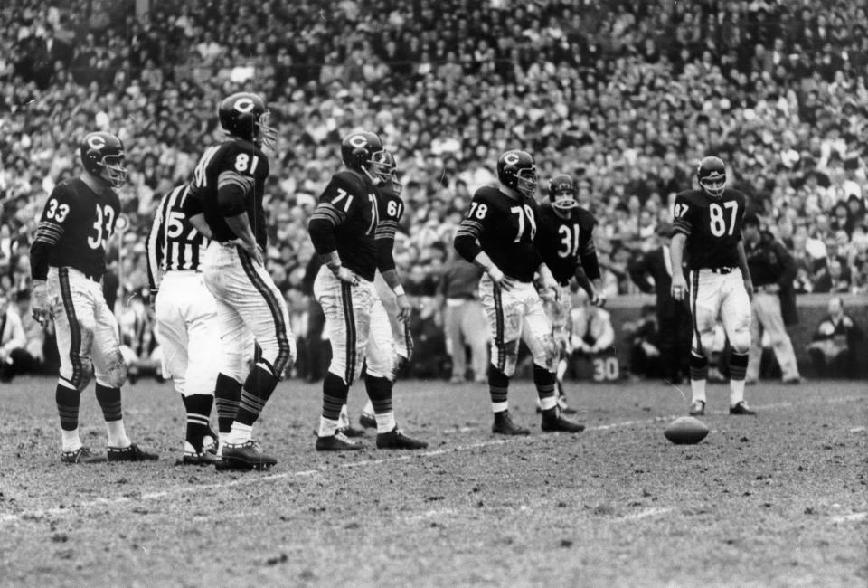 The Chicago Bears' defense held against the Green Bay Packers in Chicago on November 17, 1963. Bears players waiting for the Packers to break huddle are from left are linebacker Larry Morris (33), end Doug Atkins (81), tackle Earl Leggett (71), linebacker Bill George (61, behind Leggett), tackle Stan Jones (78), linebacker Joe Fortunato (31) and end Ed O'Bradovich (87). The Bears rolled to a 26-7 victory and broke a tie with the Packers for the western division lead.