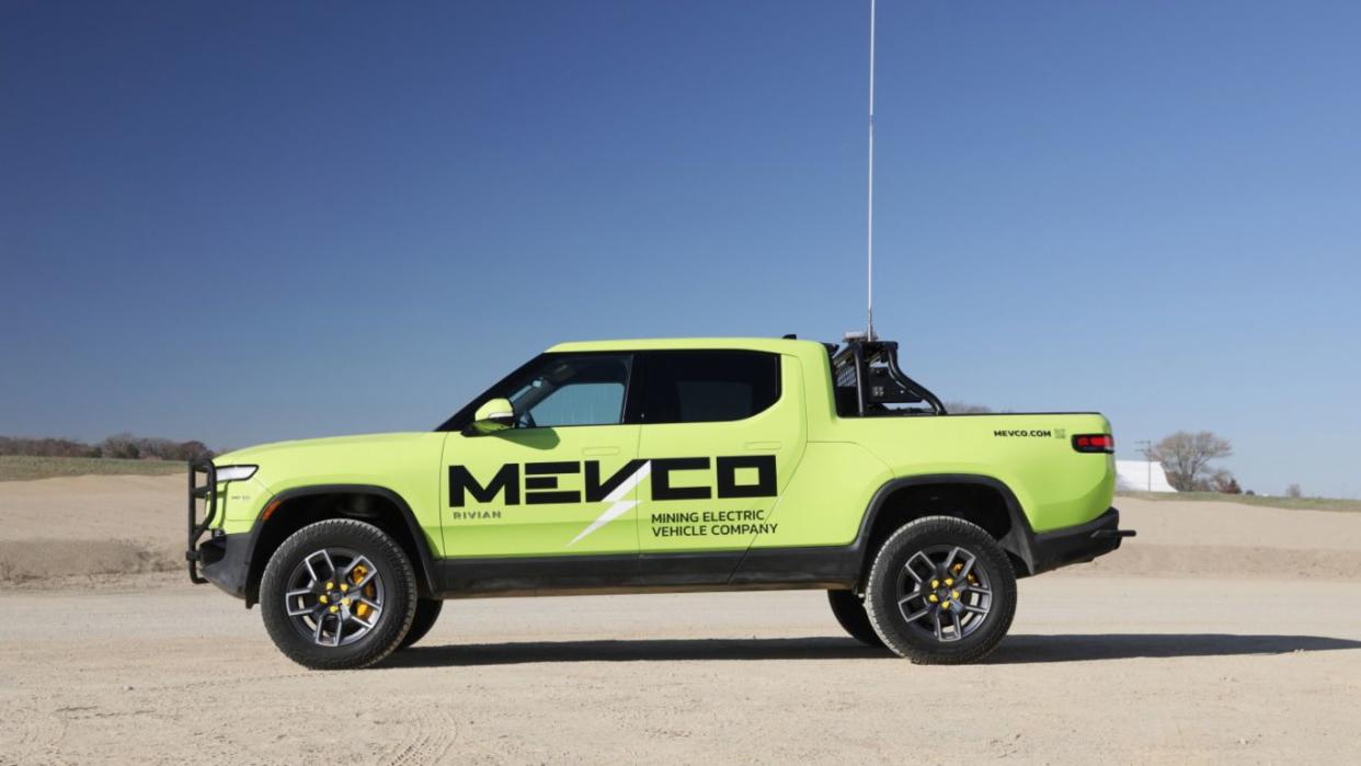 a green rivian with a flag on top of it