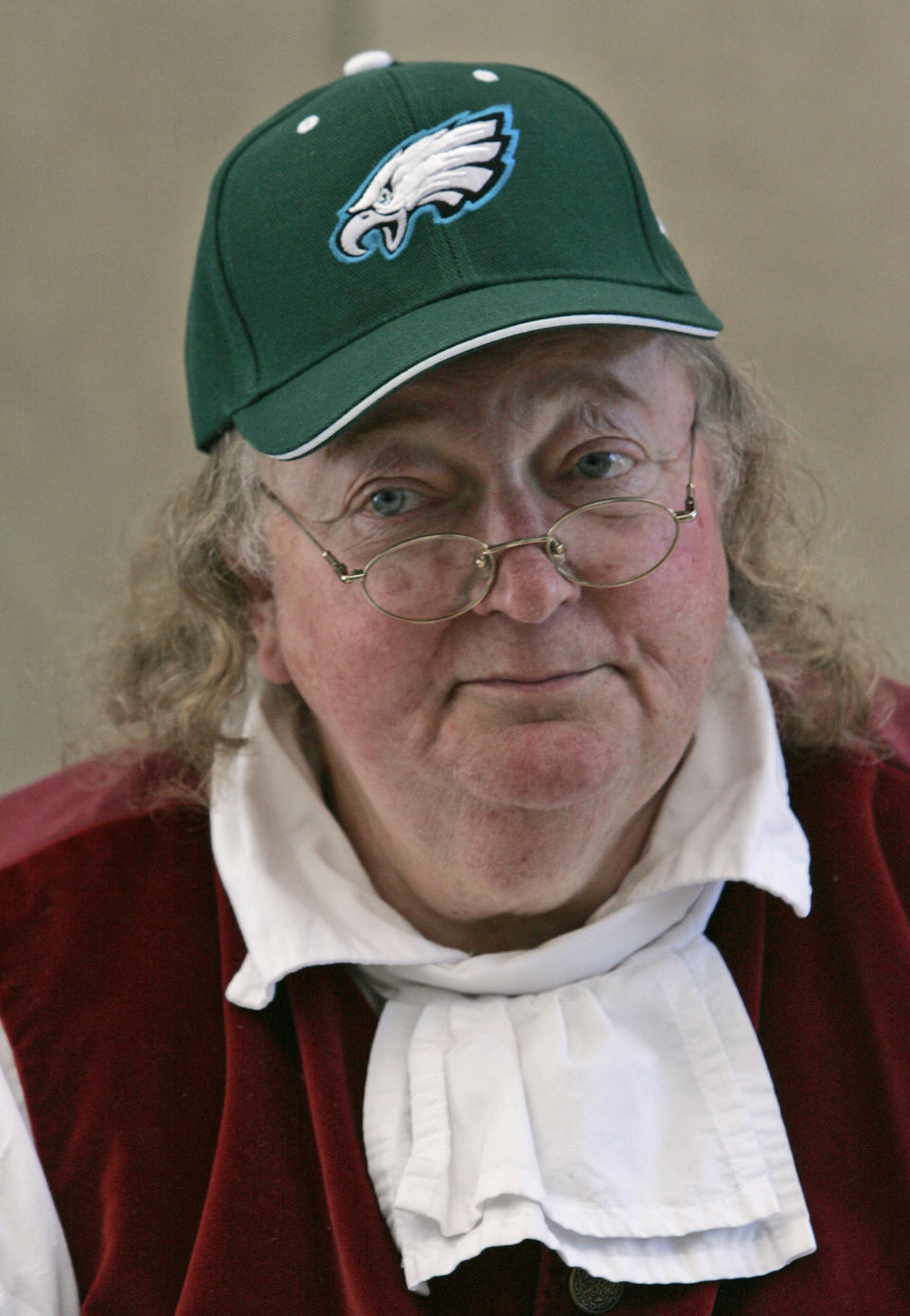 FILE – In this Feb. 2, 2005, file photo, re-enactor Ralph Archbold, portraying Benjamin Franklin, wears a Philadelphia Eagles cap during an event to promote the Super Bowl matchup between the Eagles and the New England Patriots, at the National Constitution Center in Philadelphia. Archbold, who portrayed Franklin in Philadelphia for more than 40 years, died Saturday, March 25, 2017, at age 75, according to the Alleva Funeral Home in Paoli, Pa. (AP Photo/Jacqueline Larma, File)