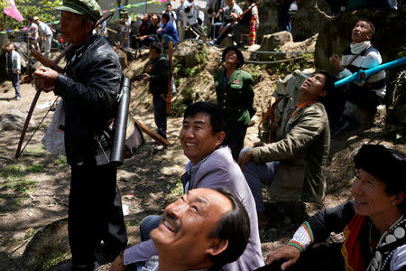 Ethnic Lisu men look at an airplane during a crossbow shooting competition in Luzhang township of Nujiang Lisu Autonomous Prefecture in Yunnan province, China, March 29, 2018. REUTERS/Aly Song