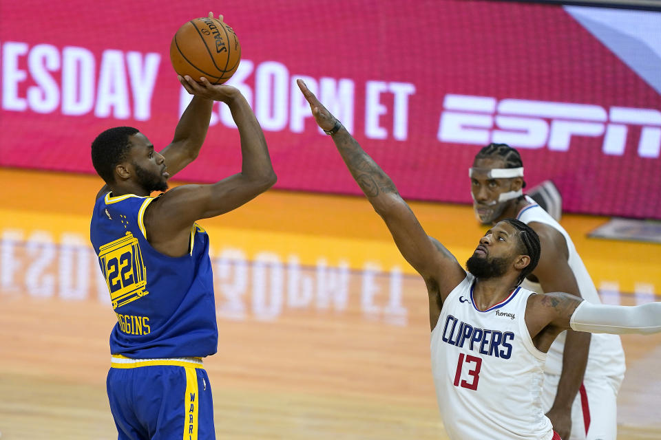 Golden State Warriors forward Andrew Wiggins (22) takes a 3-point shot over Los Angeles Clippers guard Paul George (13) during the second half of an NBA basketball game in San Francisco, Friday, Jan. 8, 2021. The Warriors won 115-105. (AP Photo/Tony Avelar)