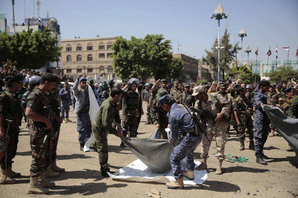 Policemen carry the body of a man, convicted of involvement in the killing of a senior Houthi official Saleh al-Samad, after his execution at Tahrir Square in Sanaa, Yemen Saturday, Sept. 18, 2021. Yemen's Houthi rebels Saturday said they executed nine people for their alleged involvement in the killing of a senior Houthi official in an airstrike by the Saudi-led coalition more than three years ago. (AP Photo/Hani Mohammed)