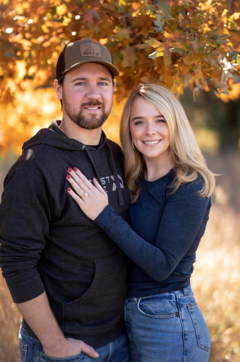 Cole Bures proposes to Samantha Camenzind during a photo shoot after she shot and killed a giant buck during a deer hunt on Nov. 12 , 2023 near Filley, Neb.. Bures surprised his future bride by popping the question after she bagged the deer. (Brenton Lammers/Lammers Media via AP)