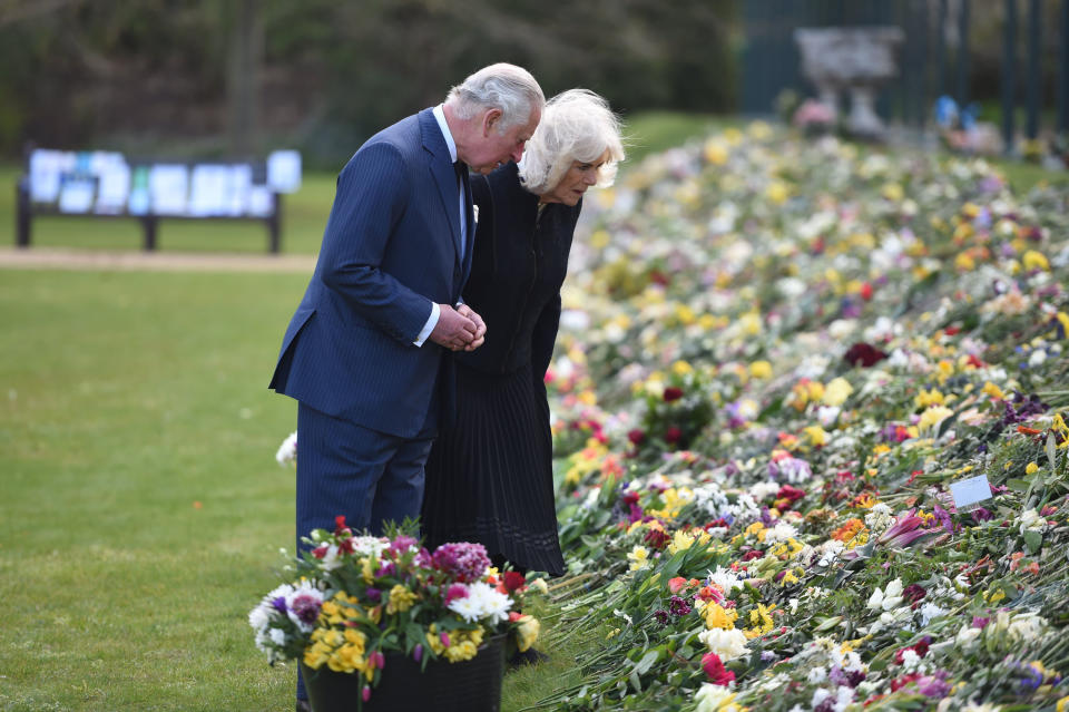 Prince Charles and Camilla looking at flowers at Prince Philip's memorial