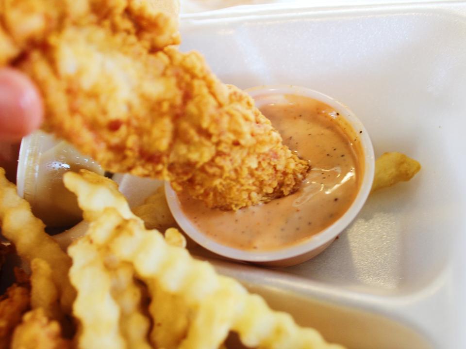 raising canes chicken tenders meal dipped in cane sauce