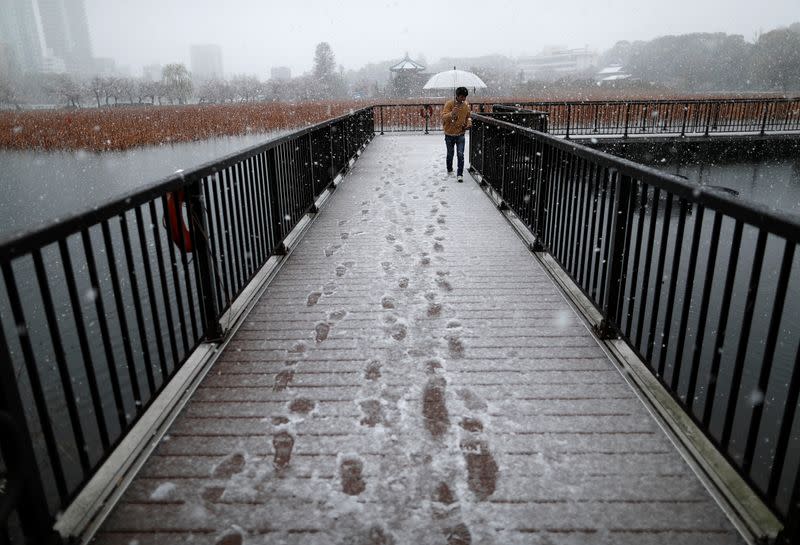 A man walks past on a bridge in a snow fall during a coronavirus disease (COVID-19) outbreak in Tokyo