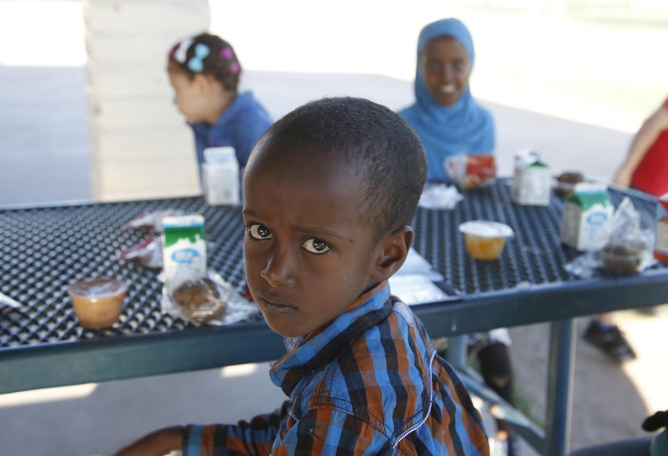 Abdul Ahmed, a second grader at Valencia Newcomer School, pauses while eating breakfast, prior to attending class Thursday, Oct. 17, 2019, in Phoenix. Children from around the world are learning the English skills and American classroom customs they need to succeed at so-called newcomer schools. Valencia Newcomer School in Phoenix is among a handful of such public schools in the United States dedicated exclusively to helping some of the thousands of children who arrive in the country annually. (AP Photo/Ross D. Franklin)