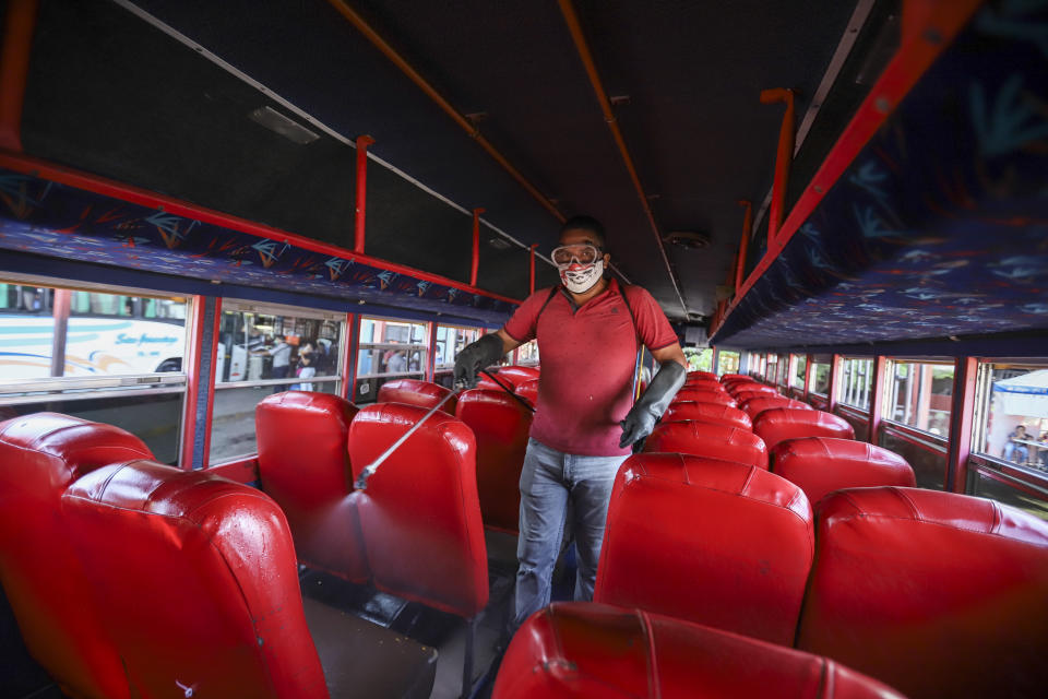 Un hombre desinfecta un autobús para evitar la propagación del nuevo coronavirus, en el mercado de Mayoreo, en Managua, Nicaragua, el 7 de abril de 2020. Los restaurantes están vacíos, hay poco tráfico en las calles y los bañistas escasean pese a ser Semana Santa aunque el gobierno pidió a los nicaragüenses que sigan con su vida pese a la pandemia de coronavirus. (AP Foto/Alfredo Zúñiga)